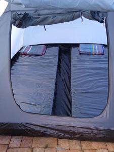 a tent with the back door open on a brick ground at The Gate Rinjani in Sajang