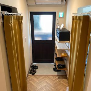 a room with a door and a pair of shoes at ゲストハウス and BAR CHITEN in Awaji