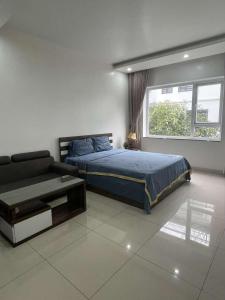 1 dormitorio con cama, sofá y ventana en Khu phố Water Front, en Hai Phong