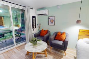 sala de estar con 2 sillas y mesa en Walking On Sunshine - Studio, en Fort Lauderdale