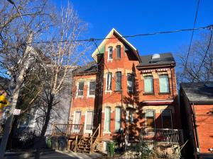 a red brick house with a black roof at 3 Bedroom Victorian with Deck and Parking in Toronto