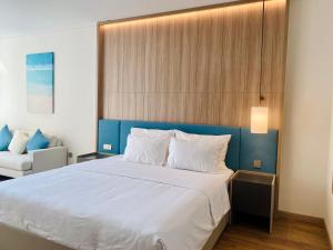 ハロンにあるBayside Bliss Apartment By A La Carte Ha Long Ocean Viewのベッドルーム1室(大型ベッド1台、青いヘッドボード付)