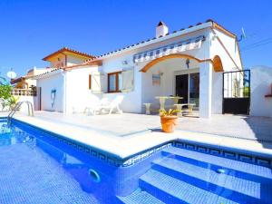 uma villa com piscina em frente a uma casa em Casa L'Escala, 3 dormitorios, 7 personas - ES-325-15 em Torroella de Montgrí