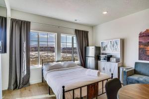 a bedroom with a bed and a chair and windows at Mountain View Studio in Heber City