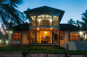 una casa con un gran porche delantero por la noche en Zawadi Beach Villas, en Matemwe