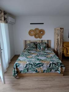 um quarto com uma cama com um edredão colorido em Studio de charme au Gosier em Le Gosier