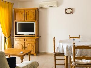 ein Wohnzimmer mit einem TV auf einem Holzschrank in der Unterkunft Apartamento L'Escala, 2 dormitorios, 4 personas - ES-325-37 in Torroella de Montgrí