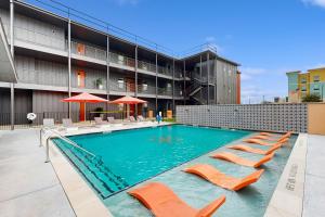 a swimming pool with orange chairs and a building at Mercer Retreat in New Braunfels