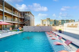 a swimming pool with lounge chairs and a hotel at Mercer Retreat in New Braunfels