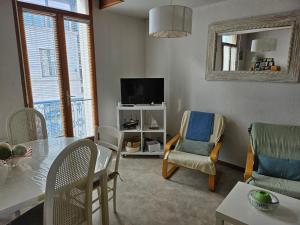 een woonkamer met een tafel en stoelen en een televisie bij Appartement Arcachon, 3 pièces, 6 personnes - FR-1-319-543 in Arcachon