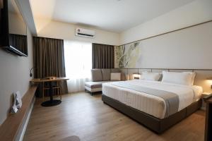una habitación de hotel con una cama y un sofá en H Elite Design Hotel, en Kota Bharu