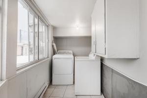 eine Küche mit einer Waschmaschine, einem Trockner und einem Fenster in der Unterkunft Spacious 3 bedroom apartment in Lasalle - 72 in Montreal
