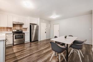 a kitchen with white cabinets and a table and chairs at Spacious 3 bedroom apartment in Lasalle - 72 in Montreal