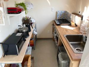 a kitchen with a sink and a counter top at ゲストハウス and BAR CHITEN in Awaji