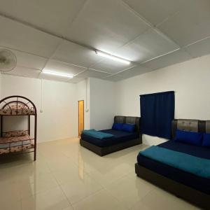 a living room with two beds and a couch at Beautiful River Homestay Kuala Pontian Rompin in Kuala Rompin