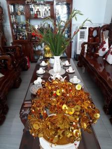 einen Tisch in einem Zimmer mit einem großen Tisch mit Geschirr in der Unterkunft Khách sạn Tường Minh in Cao Lãnh