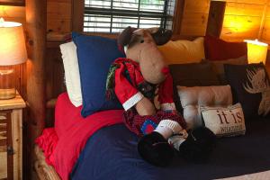 um ursinho de peluche sentado numa cama em Rudolph - Reindeer Ranch at Round Top em Carmine