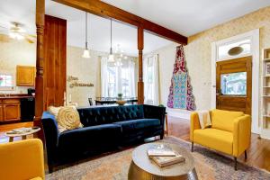 sala de estar con sofá negro y sillas amarillas en San Antonio Starlight, en San Antonio