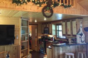cocina con armarios de madera y horno con fogones en 4 Cabins - Reindeer Ranch at Round Top, en Carmine