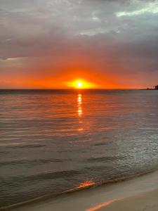 a sunset on the beach with the sun setting at Humble Boy retreat Glamping yurt in Negril