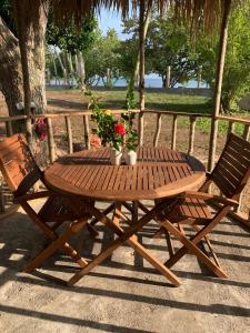 a wooden picnic table with two chairs and flowers at Humble Boy retreat Glamping yurt in Negril
