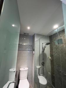 a bathroom with a toilet and a glass shower at Ramada by Wyndham Yogyakarta in Yogyakarta