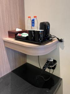 a table with a toaster and water bottles on it at Ramada by Wyndham Yogyakarta in Yogyakarta