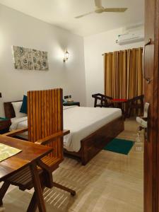 a bedroom with a bed and a table and a couch at Ananda Holiday Home in Ambalavayal