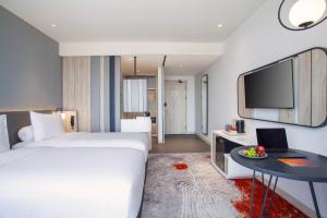 Postel nebo postele na pokoji v ubytování HARRIS Hotel & Convention Cibinong City Mall Bogor