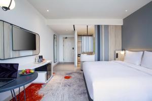 Postel nebo postele na pokoji v ubytování HARRIS Hotel & Convention Cibinong City Mall Bogor