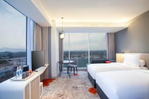 Postel nebo postele na pokoji v ubytování HARRIS Hotel & Convention Cibinong City Mall Bogor