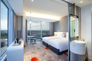 Postel nebo postele na pokoji v ubytování HARRIS Hotel & Convention Cibinong City Mall Bogor