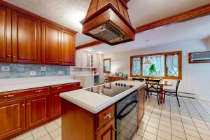 una cocina con armarios de madera y una isla de cocina en Stoney Manor, en Pocono Pines