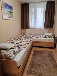 2 aparte bedden in een slaapkamer met een raam bij Tó Apartman Gunarasfürdő in Dombóvár