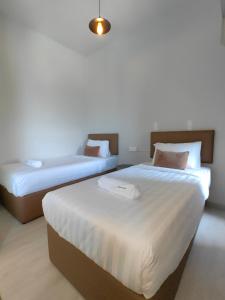 Postel nebo postele na pokoji v ubytování Jesselton Quad by Miraton Lodge 3