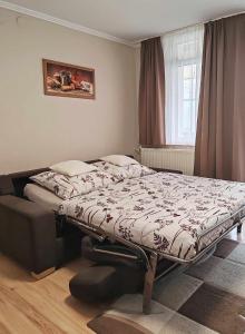 a bedroom with a bed in a room with a window at Tó Apartman Gunarasfürdő in Dombóvár