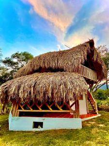 una cabaña con techo de paja encima en Las Cabanas de Pino Hostel en Santa Fe de Antioquia