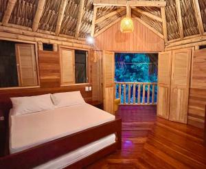 a bedroom with a bed in a wooden room at Las Cabanas de Pino Hostel in Santa Fe de Antioquia +32 photos