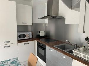 a small kitchen with a sink and a microwave at Maison à 50m de la Plage avec Parking Privatif - FR-1-482-140 in Fort-Mahon-Plage +6 photos