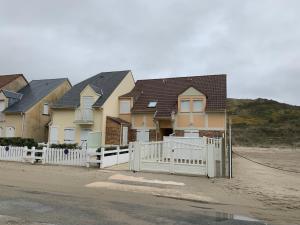 a row of houses with a white fence at Maison à 50m de la Plage avec Parking Privatif - FR-1-482-140 in Fort-Mahon-Plage