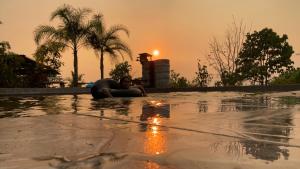 a woman laying in a swimming pool with the sunset at Monsonkeang Camping view ม่อนสันเกี๋ยง in Mae Chaem
