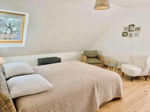 a bedroom with a large bed and a chair at Maison lumineuse La Forêt-Fouesnant proche plage, golf, avec salle de détente et 5 chambres - FR-1-481-158 in La Forêt-Fouesnant