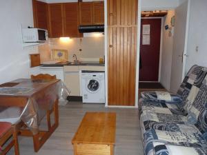 uma pequena cozinha com um sofá e uma mesa num quarto em Appartement Bormes-les-Mimosas, 1 pièce, 2 personnes - FR-1-251-728 em Bormes-les-Mimosas