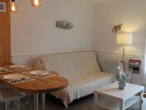 uma sala de estar com um sofá e uma mesa em Appartement Bormes-les-Mimosas, 2 pièces, 4 personnes - FR-1-251-735 em Bormes-les-Mimosas