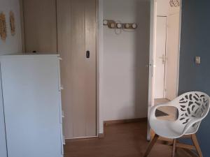 uma cadeira branca num quarto com um frigorífico em Appartement Bormes-les-Mimosas, 2 pièces, 4 personnes - FR-1-251-735 em Bormes-les-Mimosas