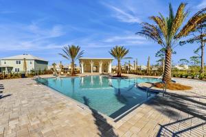 Saint Joe BeachにあるWindmark - Jasmine by the Beachのヤシの木と建物のあるプール