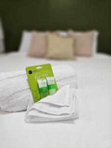 two beds with white towels and a green book on them at Home Near Downtown Norfolk in Norfolk