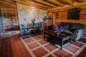 una sala de estar con sofá y mesa en una cabaña en Gîte de l'herboriste, en Sainte-Rose-du-Nord
