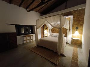 1 dormitorio con 1 cama con dosel en Mirador Escondido del Chicamocha a 22km de Barichara, en Villanueva
