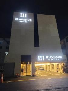 a building with lit up signs on the side of it at H Avenue Hotel Geumho in Gwangju